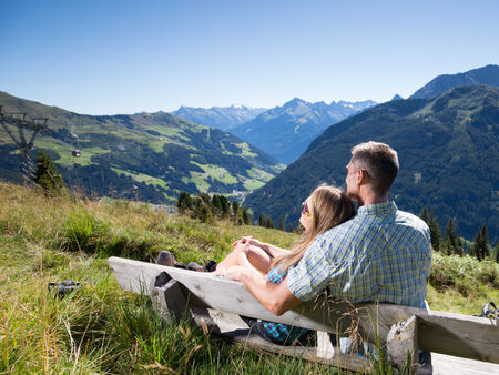 Ein Mann und eine Frau sitzen auf einer Bank und genießen die Sonne