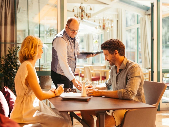 Paar bekommt im Cafe Kaiserbründl im Neuhintertux Getränke serviert