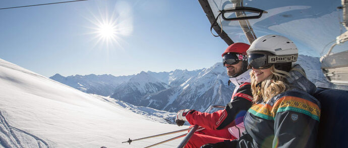Ski Pauschale Skifahrer am Liftsessel in der Sonne