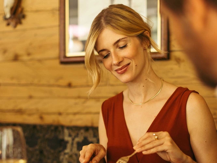 Frau genießt das Abendessen in der Jagdstube im Neuhintertux