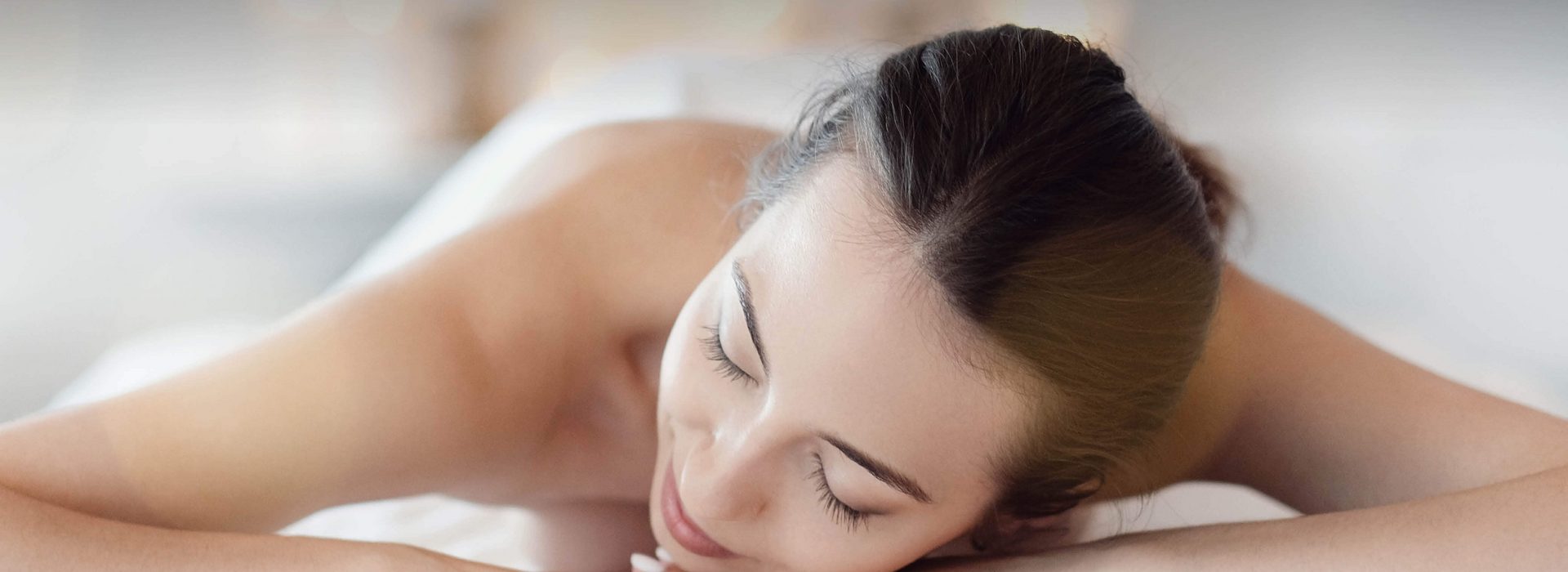Frau liegt auf Massageliege am Bauch