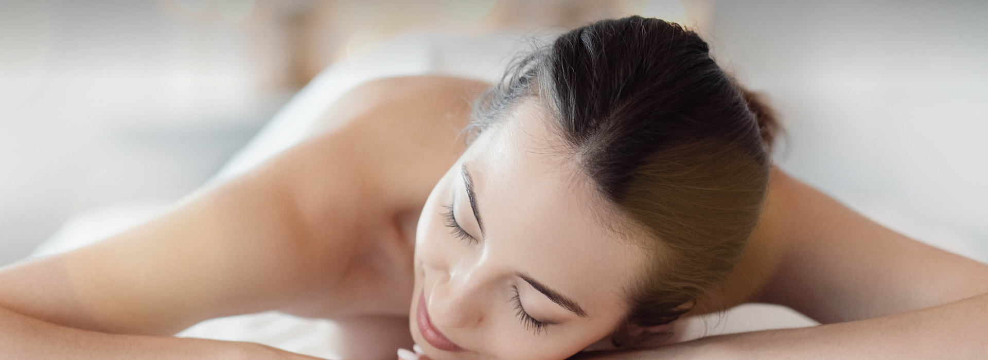 Frau liegt auf Massageliege am Bauch
